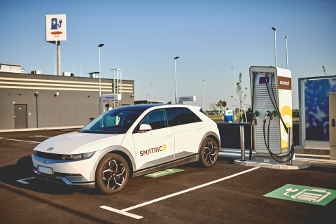 E-Auto lädt an einer Ladestation bei einer Tankstelle